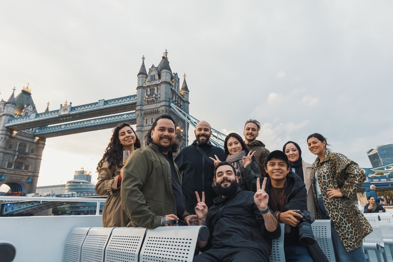 A group of Pexels photographers on a boat on the Thames, with Tower Bridge behind them.